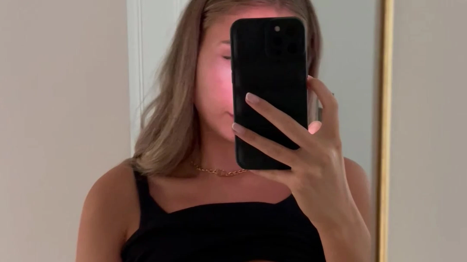 Lillian Phillips taking a selfie in front of the mirror lifting her top up showing her tits